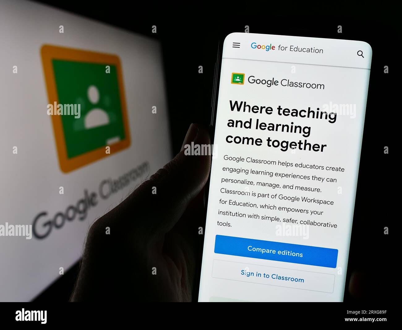 Personne tenant le téléphone portable avec la page Web de la plate-forme d'apprentissage mixte Google Classroom sur l'écran en face du logo. Concentrez-vous sur le centre de l'écran du téléphone. Banque D'Images