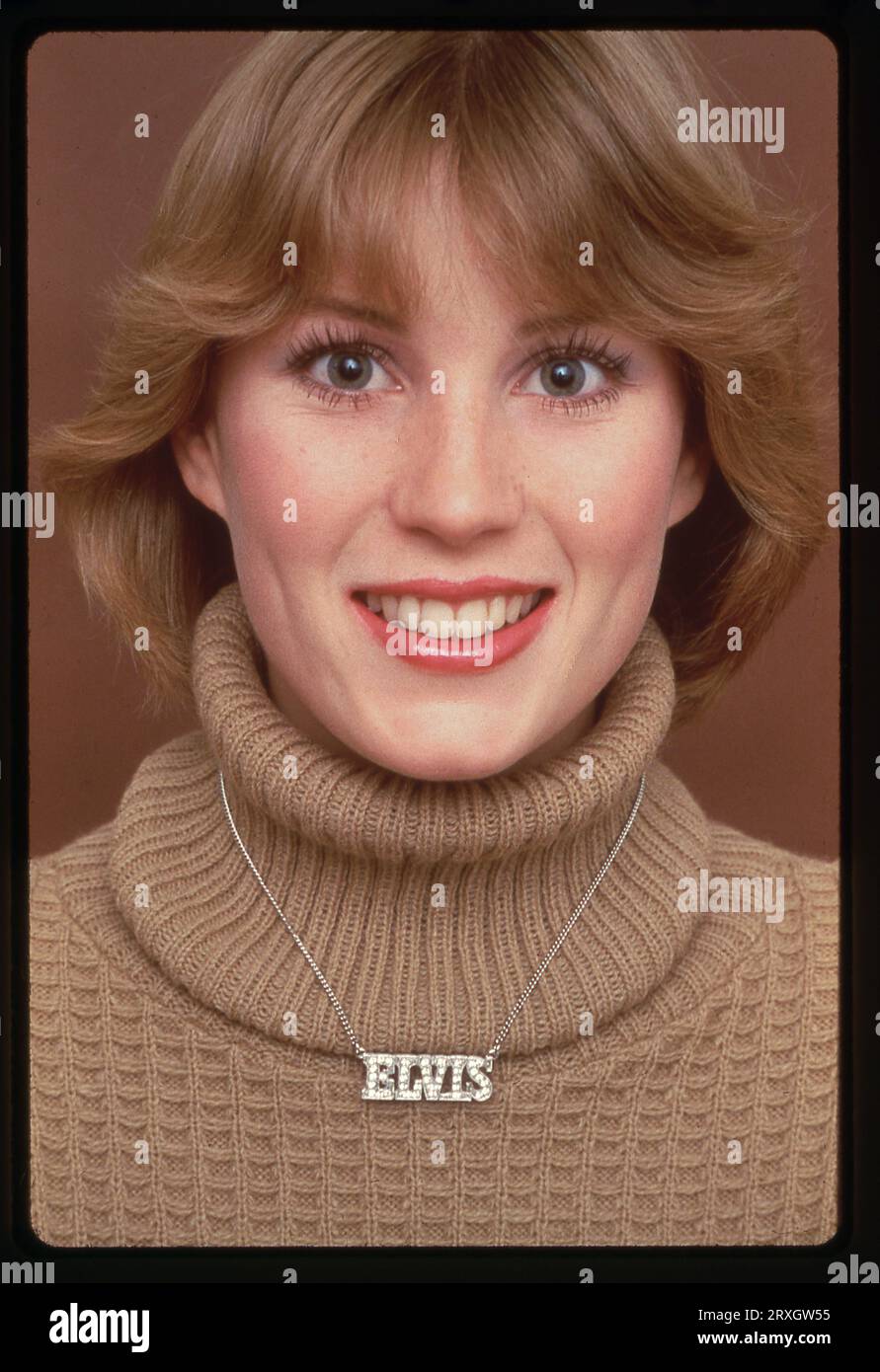 Un portrait posé en 1979 d'un beau mannequin portant un collier Elvis. Banque D'Images