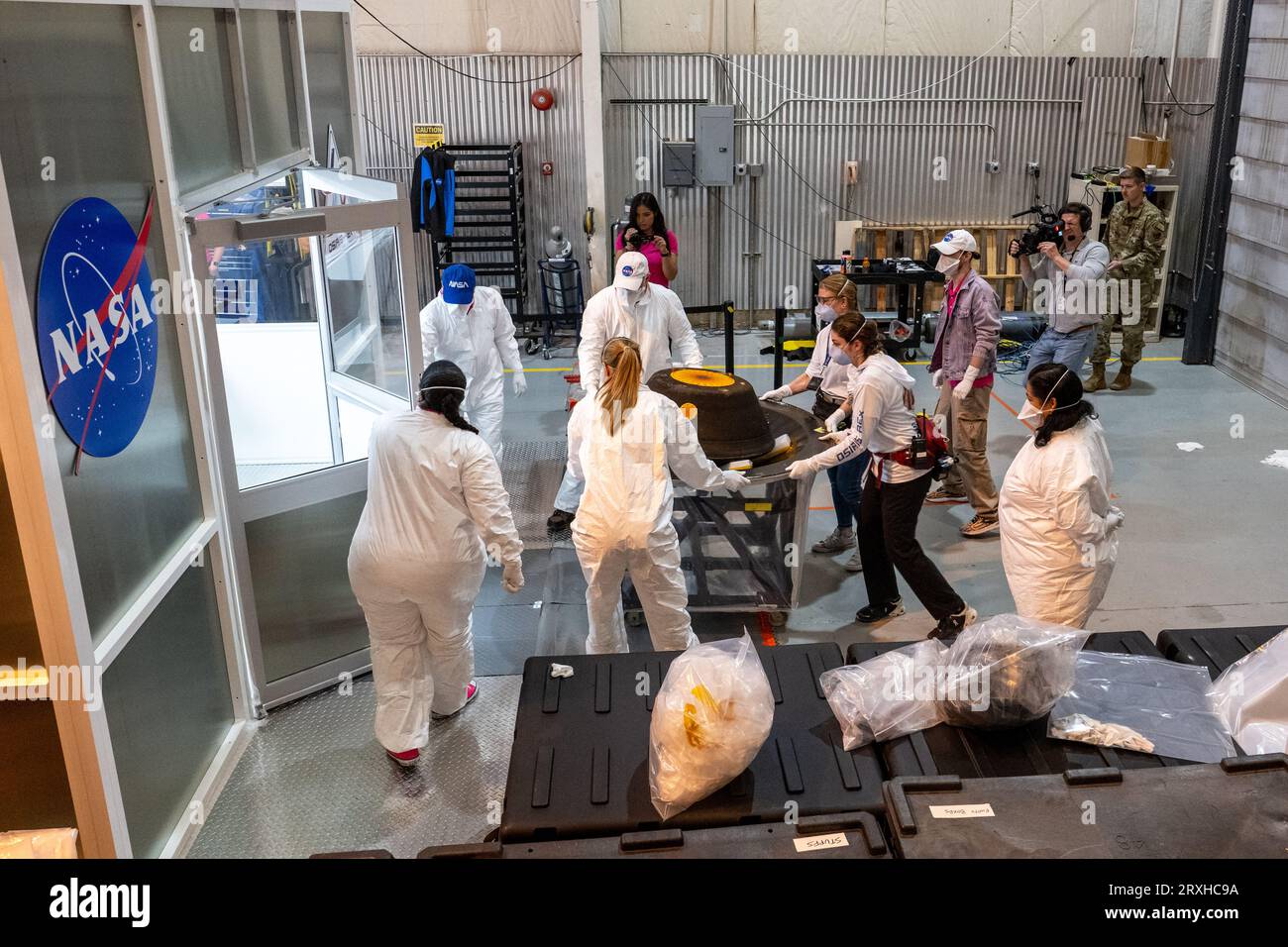 Dugway (États-Unis d ' Amérique). 24 septembre 2023. Dugway (États-Unis d ' Amérique). 24 septembre 2023. Les équipes de curation transfèrent la capsule de retour d'échantillons transportant des échantillons d'astéroïdes de la mission OSIRIS-Rex de la NASA dans une salle blanche après son atterrissage au champ d'essais et d'entraînement de l'Utah, le 24 septembre 2023 à Dugway, Utah. L'échantillon a été prélevé sur l'astéroïde Bennu en octobre 2020 par la sonde spatiale OSIRIS-Rex et retourné sur Terre lors d'un survol. Crédit : Keegan Barber/NASA/Alamy Live News Banque D'Images