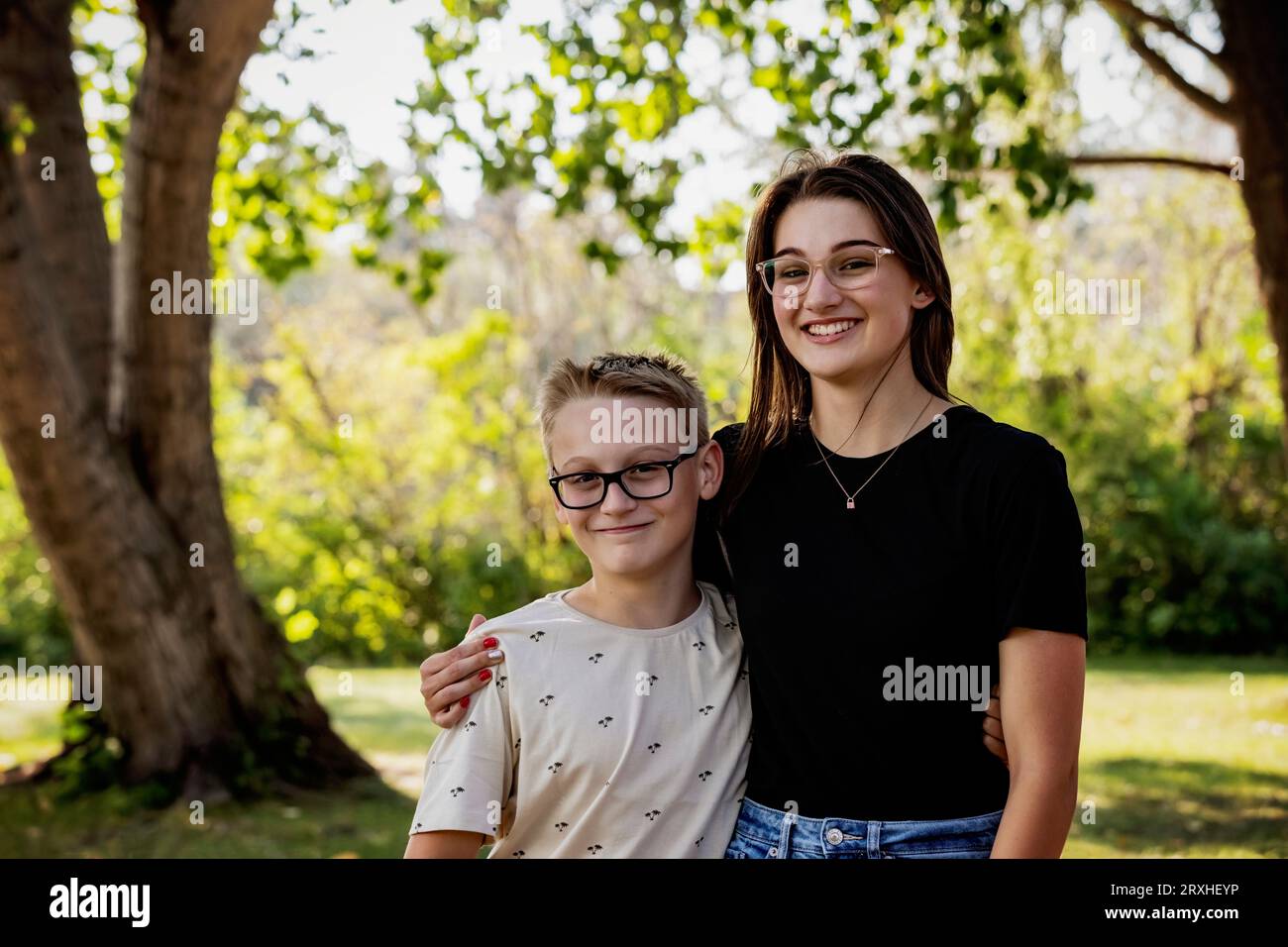 Portrait en plein air de deux frères et sœurs dans une relation amoureuse, passant du temps de qualité ensemble dans un parc de la ville au cours d'une chaude après-midi d'automne Banque D'Images