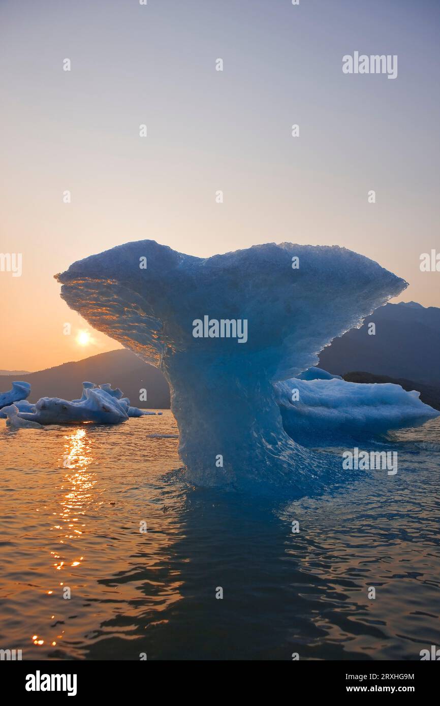 Le soleil se couche au-delà d'une sculpture de glace D'Une queue de baleines, créée par les forces naturelles de l'érosion, dans le lac Mendenhall près de Juneau Alaska. Banque D'Images