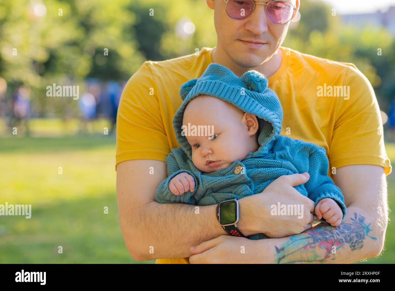 Jeune père avec son bébé nouveau-né dans le parc par une journée ensoleillée Banque D'Images