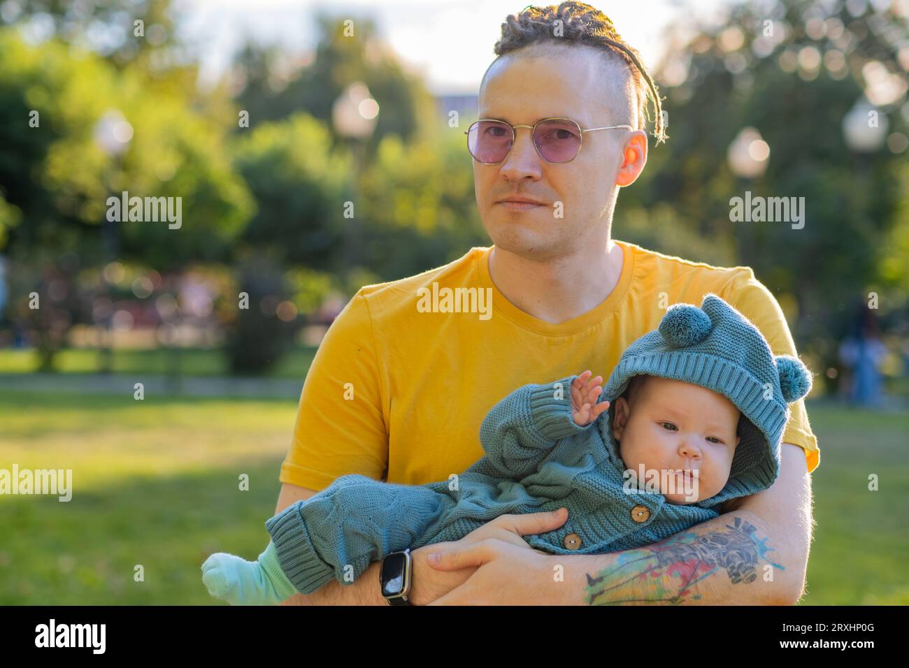 Jeune père avec son fils nouveau-né dans le parc par une journée ensoleillée Banque D'Images