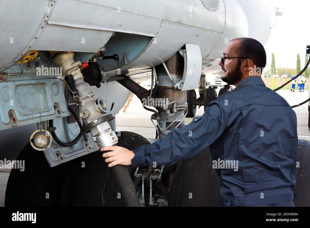 Technicien de l'aviation ravitaillant l'avion à l'aéroport. Banque D'Images