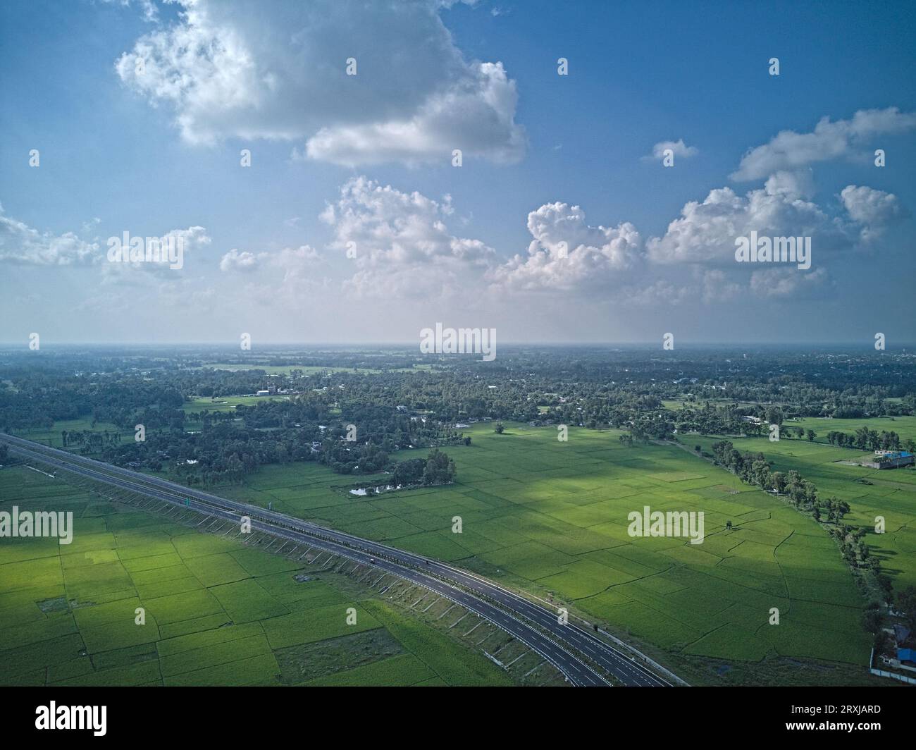 09.16.2023. Raiganj Bengale occidental Inde. Vue aérienne de dessus de la route nationale passant à travers des terres agricoles vertes Banque D'Images