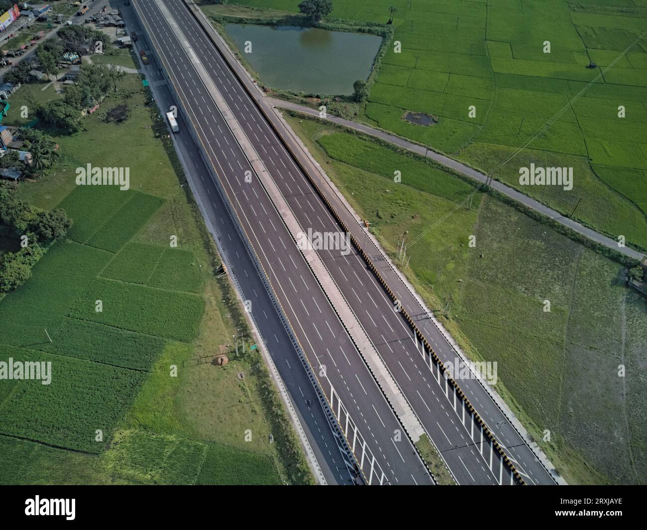 09.16.2023. Raiganj Bengale occidental Inde. Vue aérienne de dessus de la route nationale passant à travers des terres agricoles vertes Banque D'Images