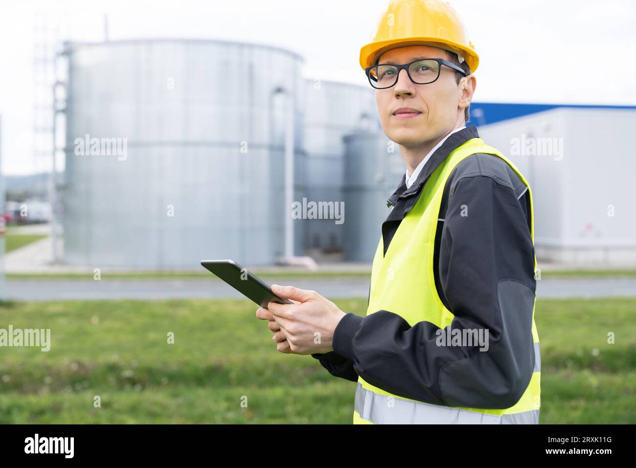 Concevoir avec une tablette numérique sur un fond de réservoirs de gaz. Banque D'Images