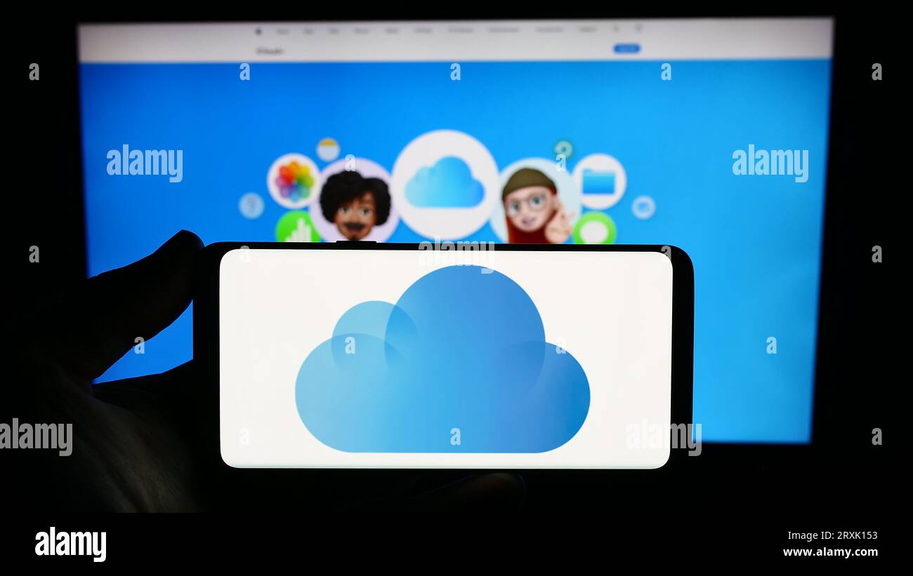 Personne tenant smartphone avec logo de la plate-forme de stockage cloud Apple iCloud sur l'écran en face du site Web. Concentrez-vous sur l'affichage du téléphone. Banque D'Images