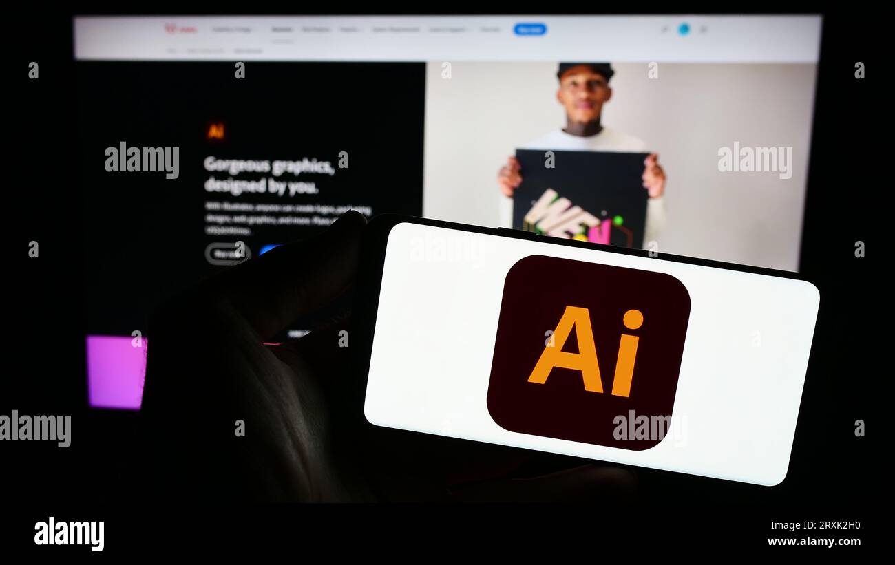 Personne tenant le smartphone avec le logo de l'éditeur graphique vectoriel Adobe Illustrator sur l'écran en face du site Web. Concentrez-vous sur l'affichage du téléphone. Banque D'Images