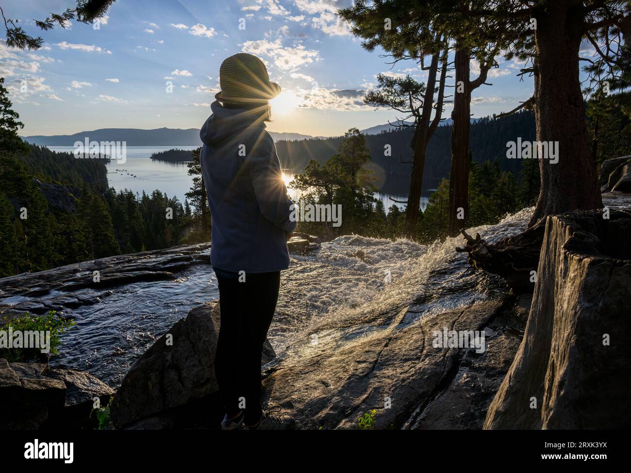 Femme debout près des Lower Eagle Falls au lever du soleil. Emerald Bay en arrière-plan. Lake Tahoe. Californie. Banque D'Images