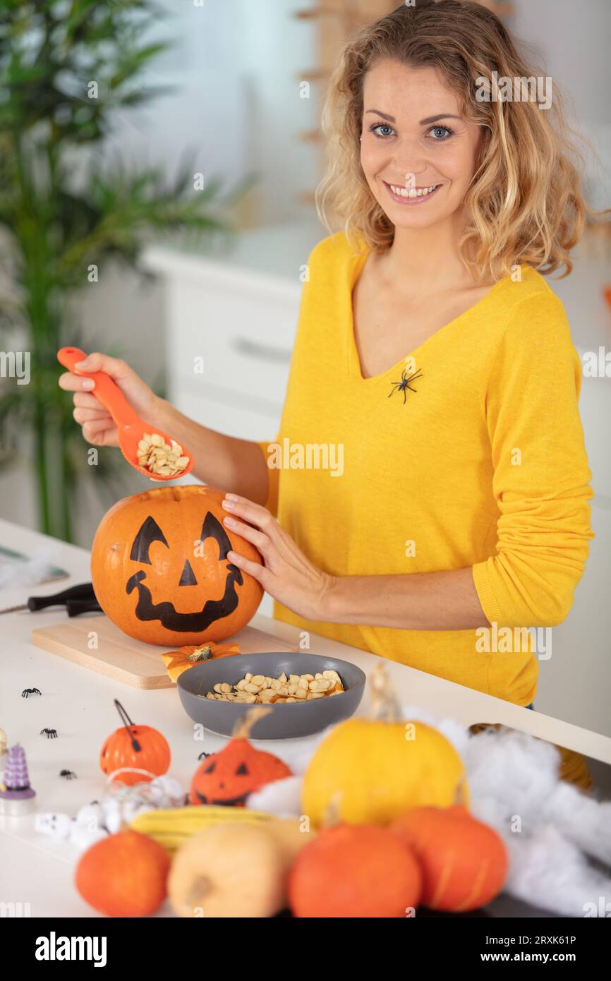 une femme se prépare pour halloween et sculpte des citrouilles Banque D'Images