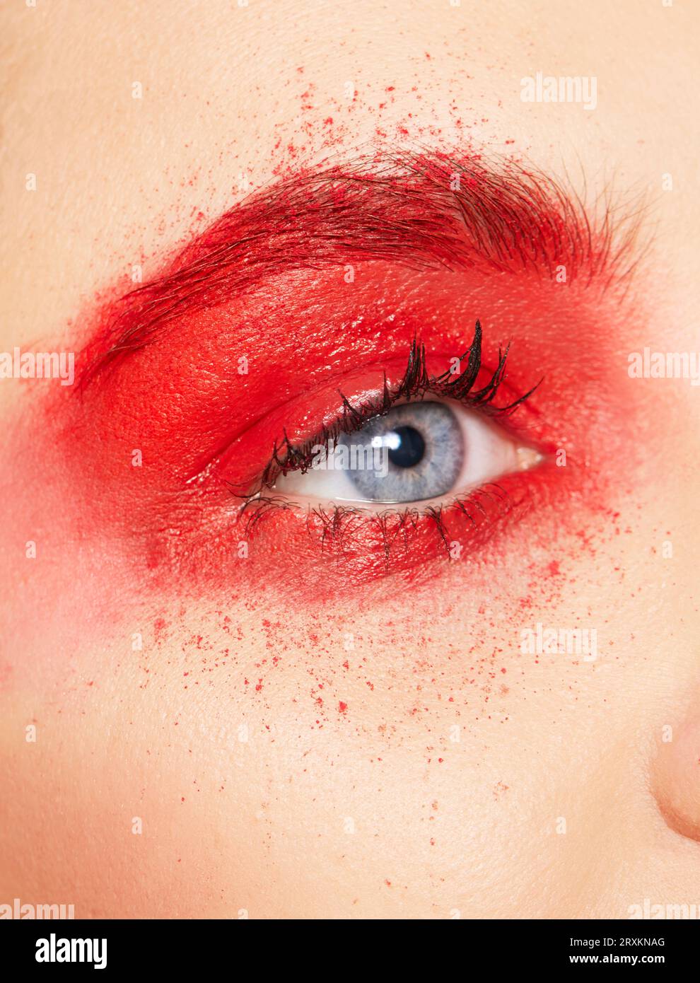 Gros plan de l'œil de jeune femme avec fard à paupières rouge Banque D'Images