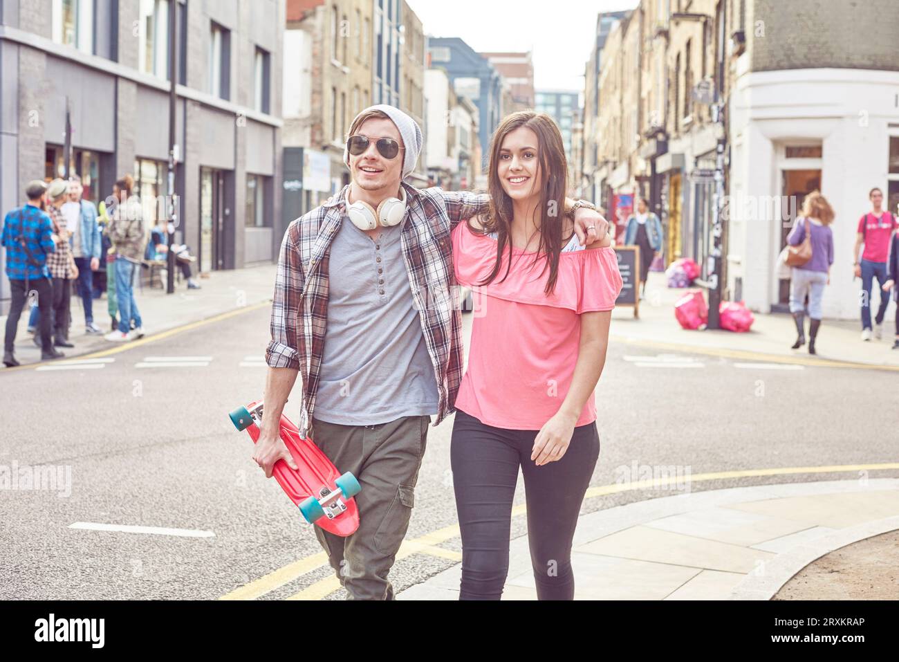 Teenage couple en train de marcher le long des rues Banque D'Images