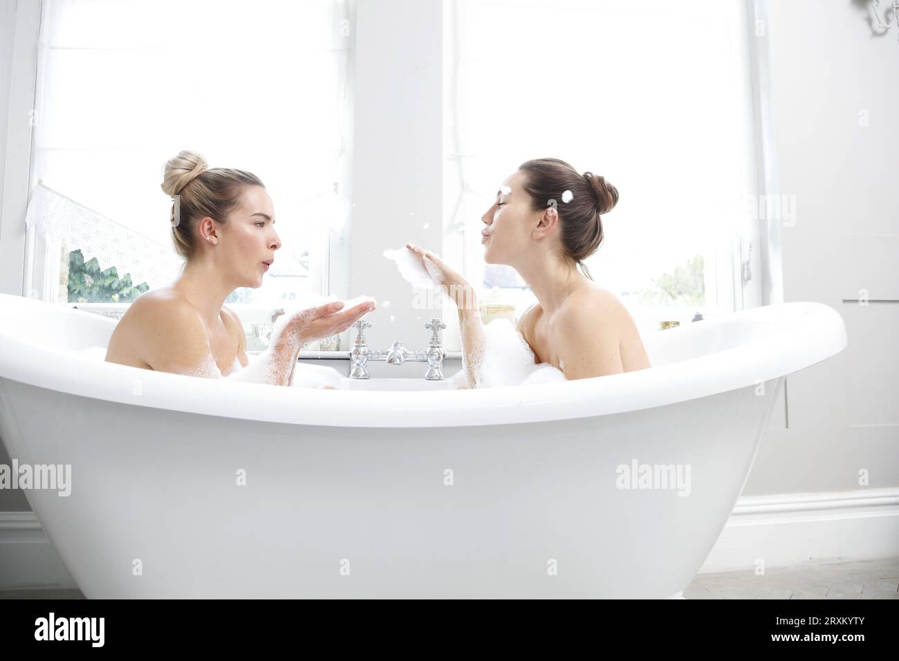 Deux femmes profitant d'un bain moussant ensemble Banque D'Images