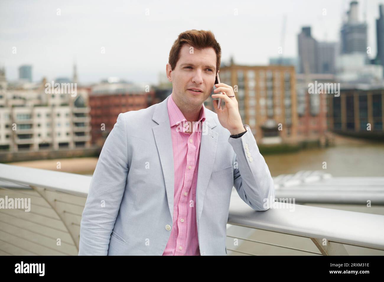 Mid adult man on phone in city Banque D'Images