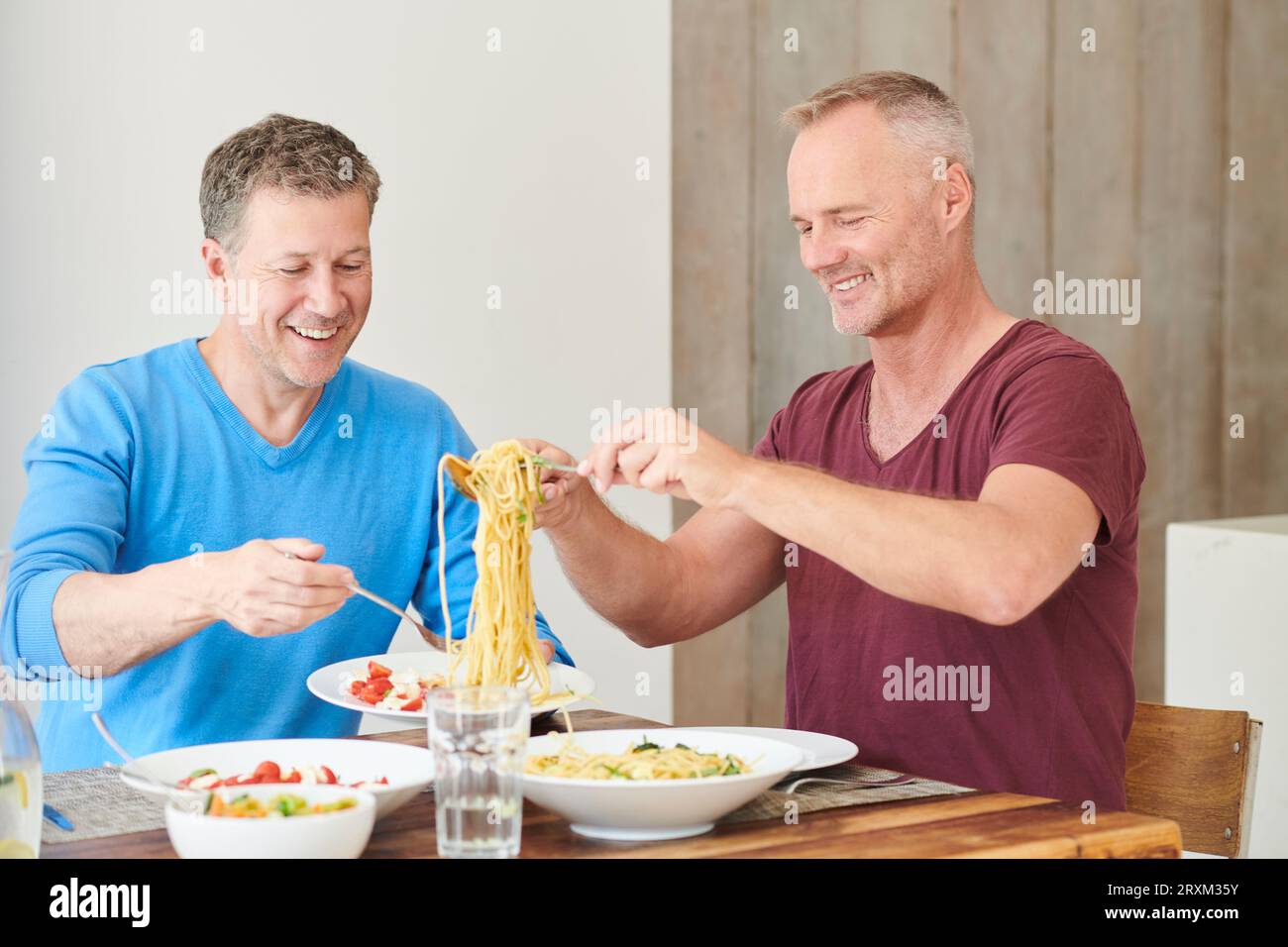 Gay couple eating dinner Banque D'Images