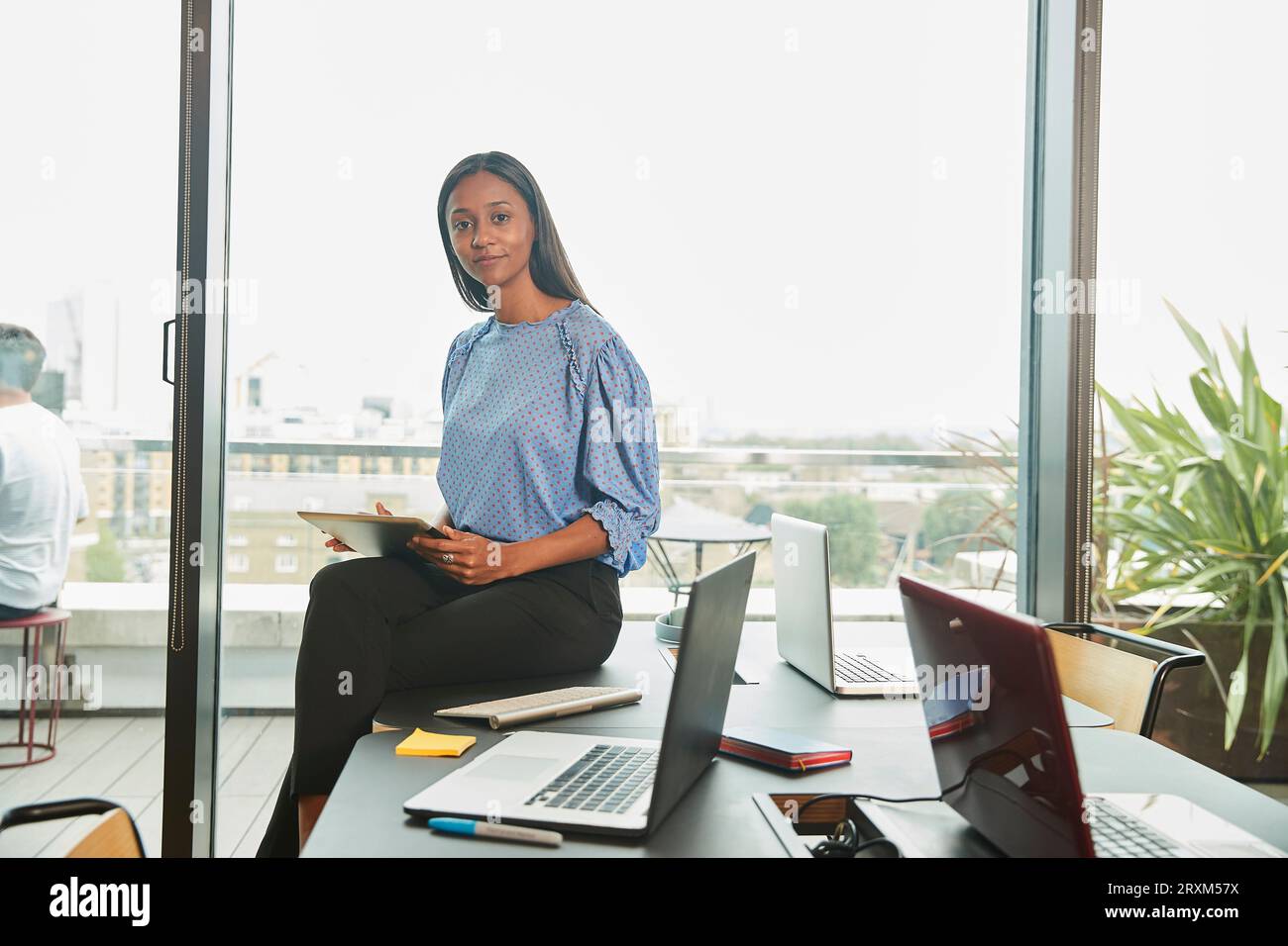 Mid adult woman holding digital tablet in conference room Banque D'Images