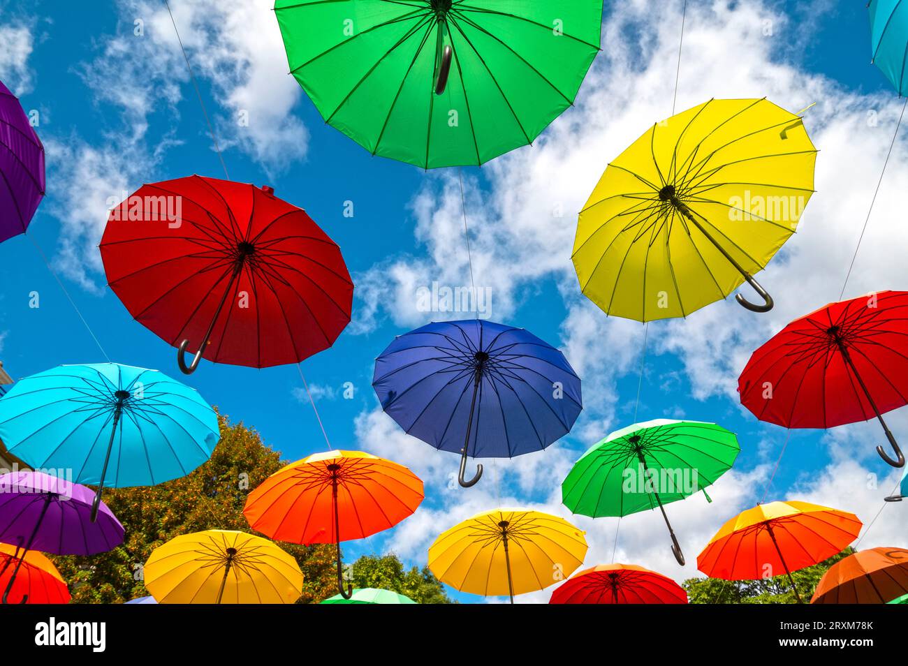 Beaucoup de parapluies colorés comme décoration dans une rue de la ville contre le ciel bleu Banque D'Images