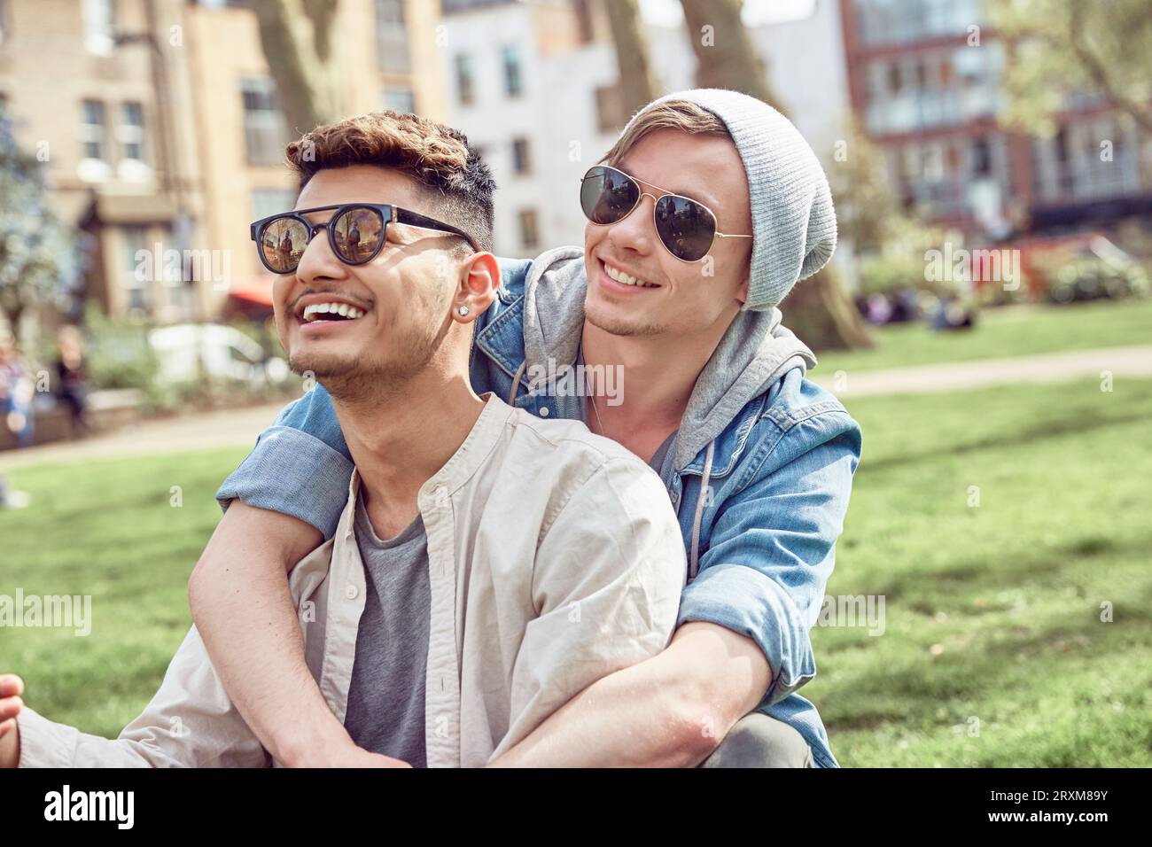 Gay couple sitting in park Banque D'Images