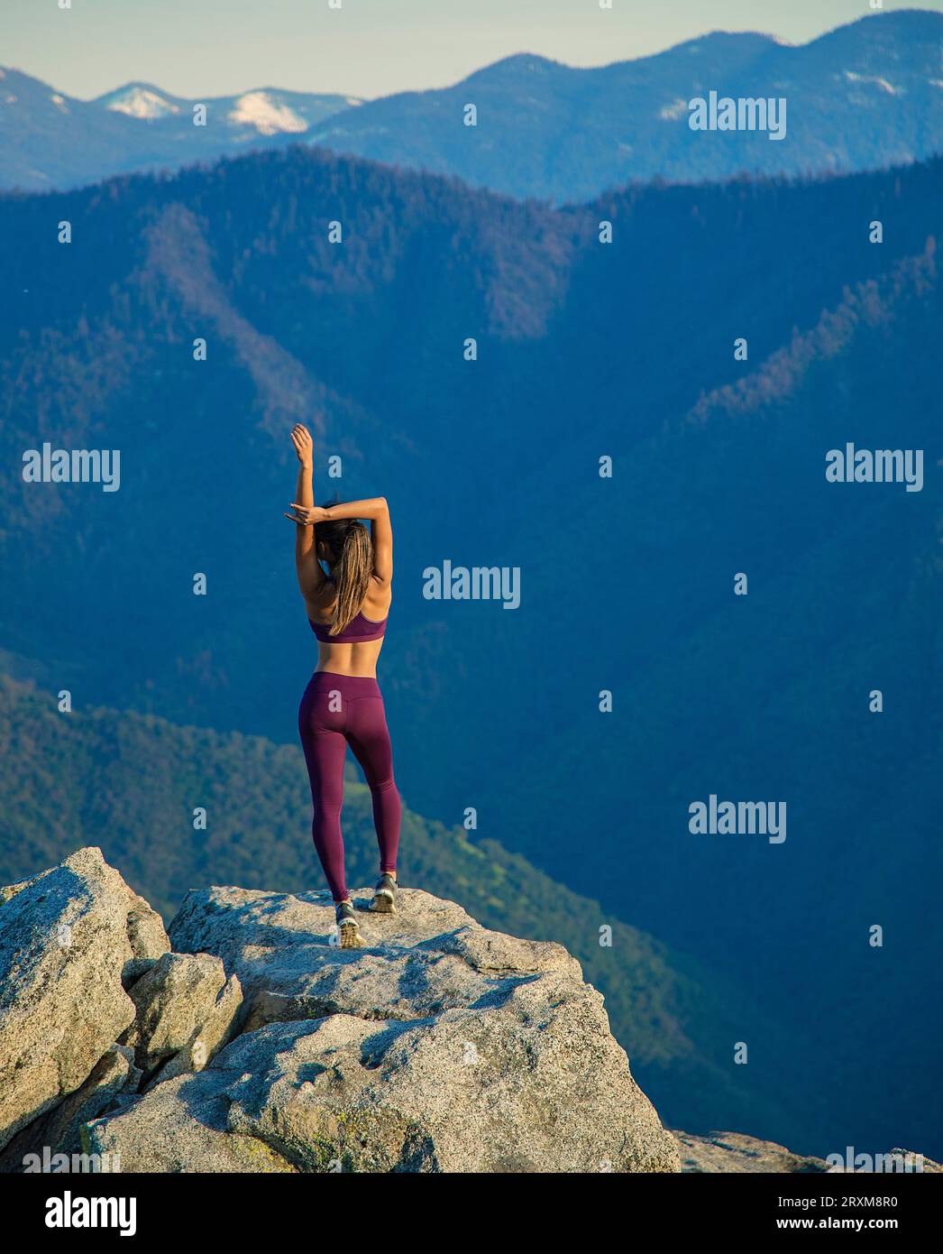 Jeune femme qui s'étend sur des roches de montagne Banque D'Images