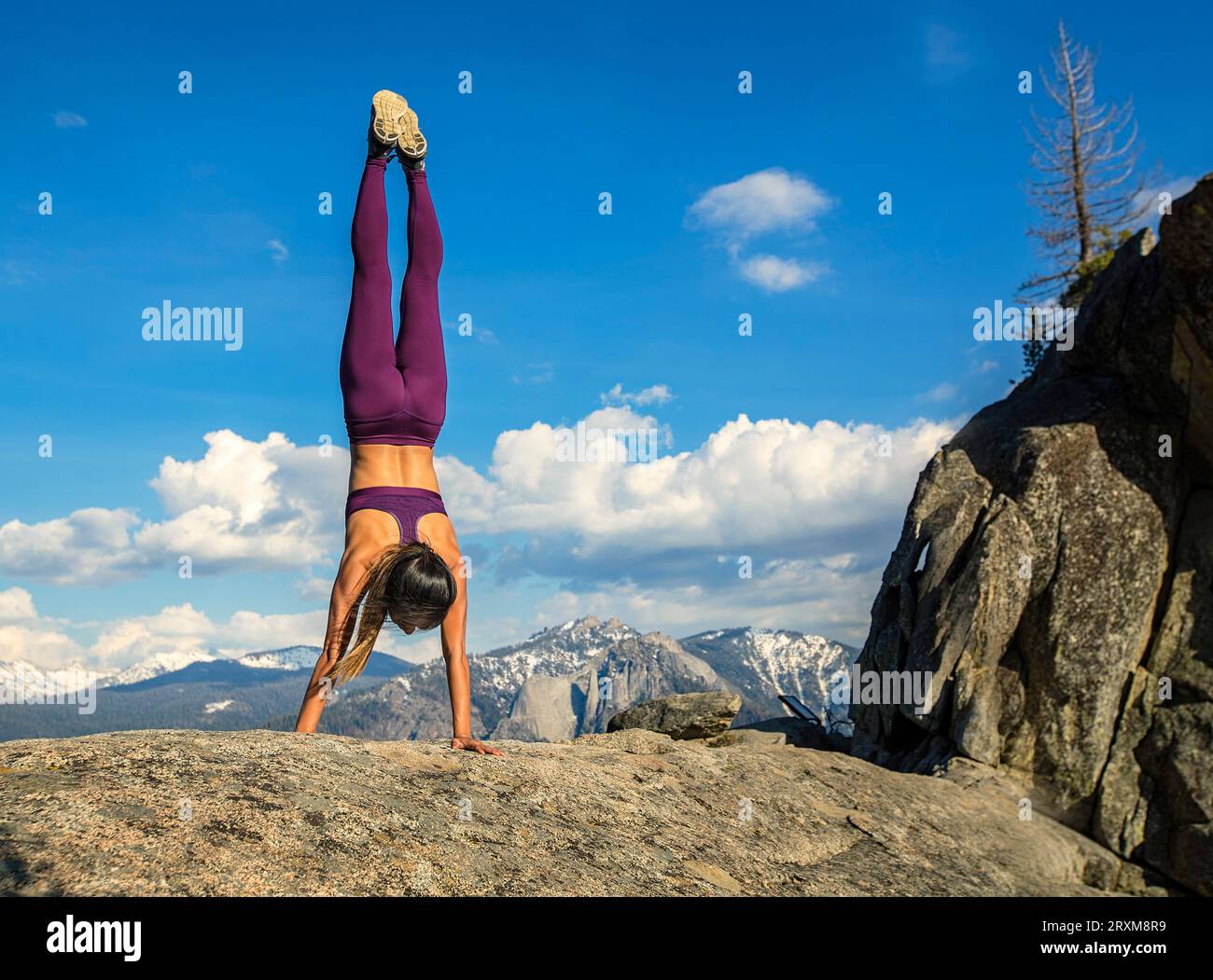 Young woman doing handstand on a rock Banque D'Images