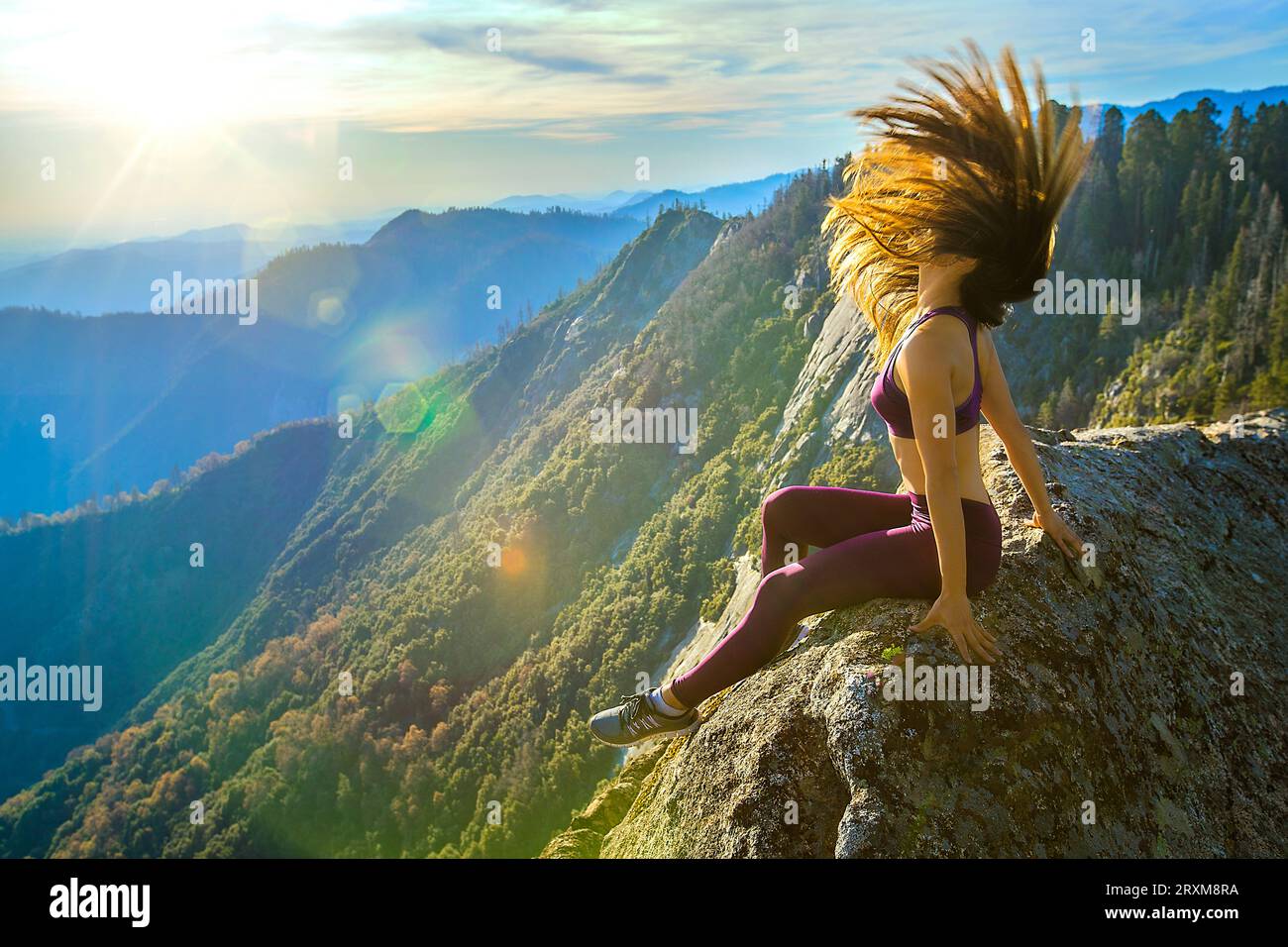 Jeune femme rejetant ses cheveux sur une montagne rock Banque D'Images