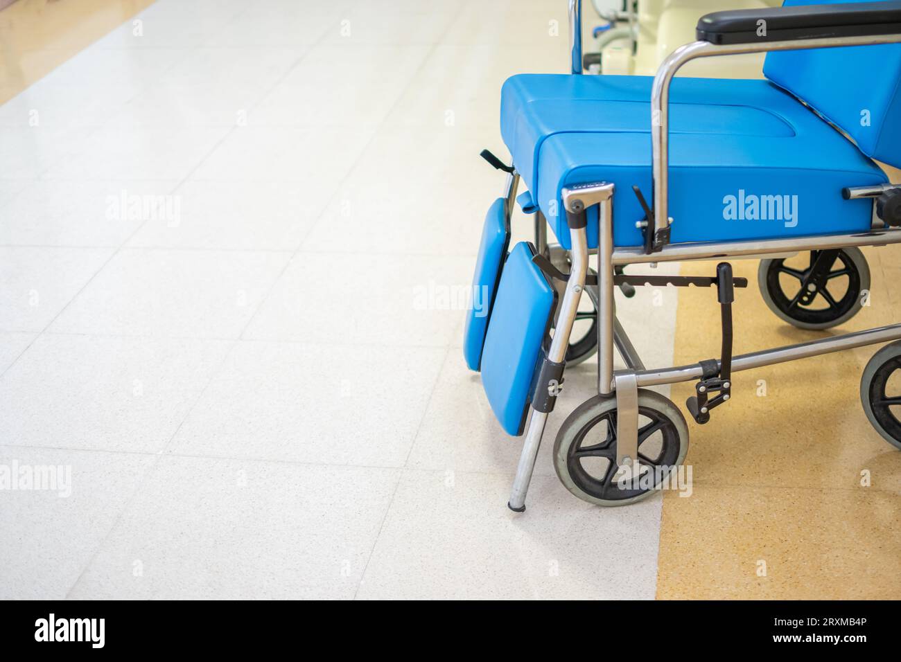 Vue rapprochée du fauteuil roulant rembourré bleu spécialisé avec couloir de l'hôpital Banque D'Images