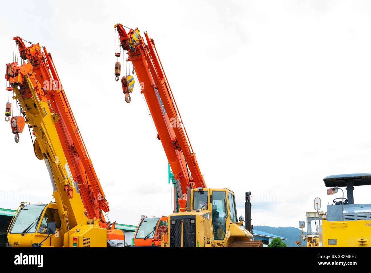 Machines industrielles. Grue de construction pour le levage de charges lourdes dans l'industrie. Grue de construction jaune avec crochet. Équipement à louer et à vendre. Grue Banque D'Images