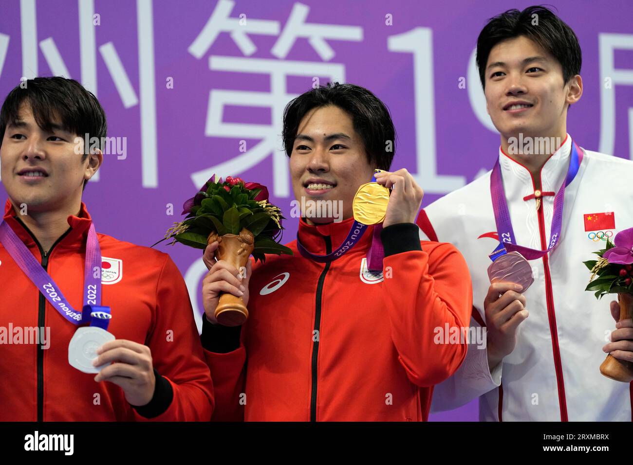 Medalists, from left to right, Japan's Daiya Seto, silver, Japan's Tomoru Honda, gold, and China's Wang Shun, bronze, celebrate on the podium during the victory ceremony for the men's 400m individual medley swimming at the 19th Asian Games in Hangzhou, China, Tuesday, Sept. 26, 2023. (AP Photo/Lee Jin-man) Banque D'Images