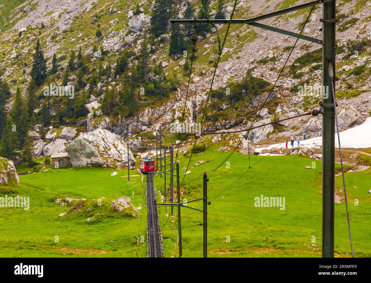 Superbe vue sur le paysage montagneux avec le train à crémaillère le plus raide du monde de couleur rouge descendant de la station de montagne Pilatus Kulm tous... Banque D'Images