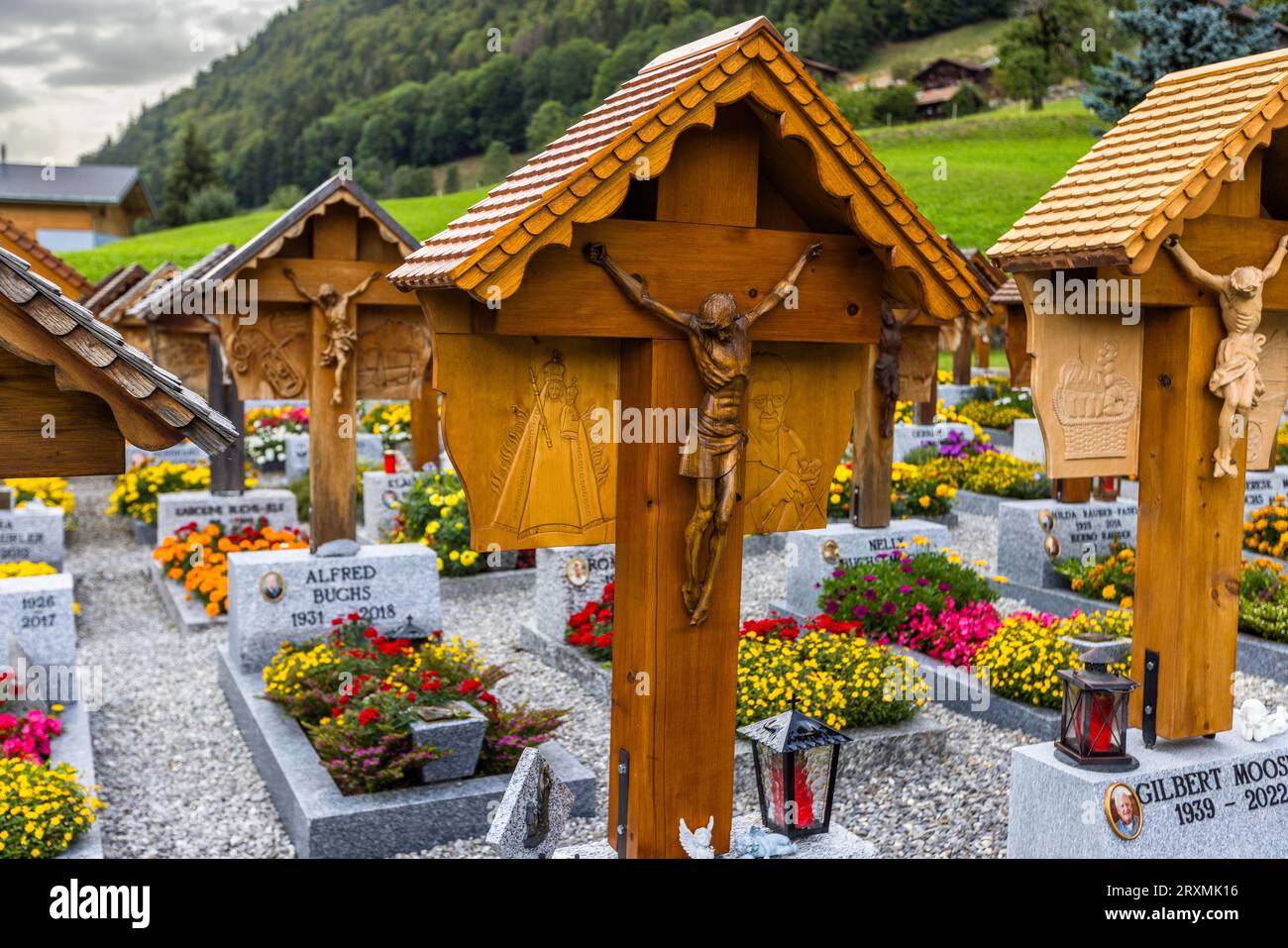 Dans le cimetière derrière l'église de St. Stephen à Jaun, toutes les tombes individuelles ont une croix en bois sculptée avec une figure du Christ et des sculptures représentant la profession ou le passe-temps du défunt. Jaun, Suisse Banque D'Images