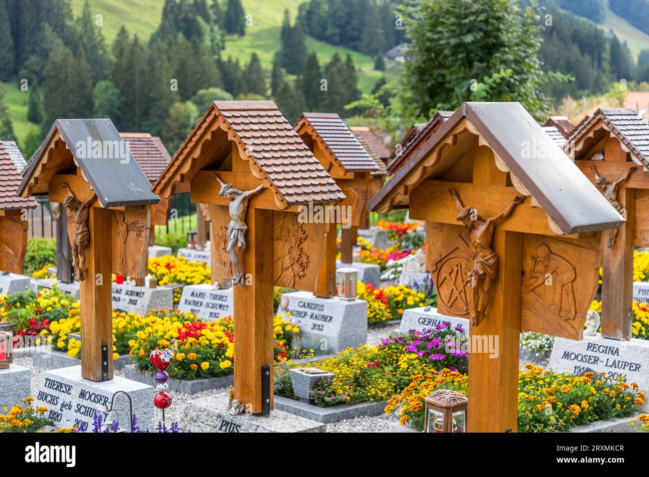 Dans le cimetière derrière l'église de St. Stephen à Jaun, toutes les tombes individuelles ont une croix en bois sculptée avec une figure du Christ et des sculptures représentant la profession ou le passe-temps du défunt. Jaun, Suisse Banque D'Images