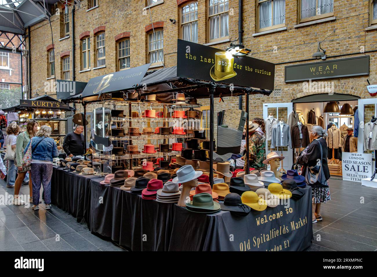 Les gens naviguant sur un stand de chapeau à Old Spitalfields Market, Londres E1 Banque D'Images