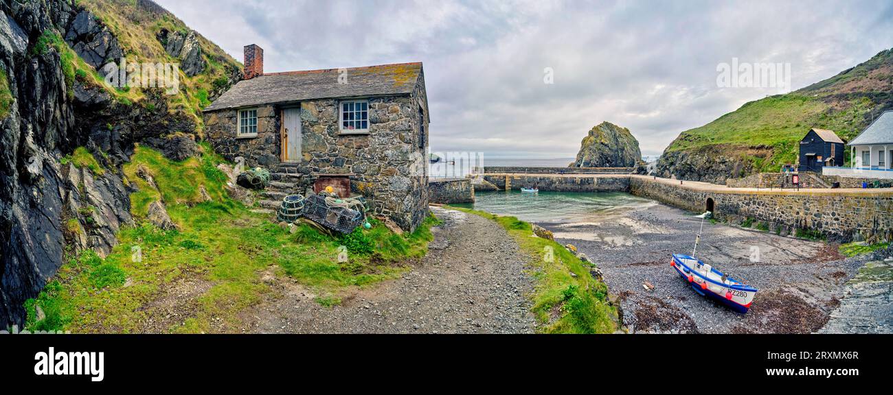 Village de pêcheurs isolé avec maison en pierre au premier plan, Mullion, Angleterre, Royaume-Uni Banque D'Images