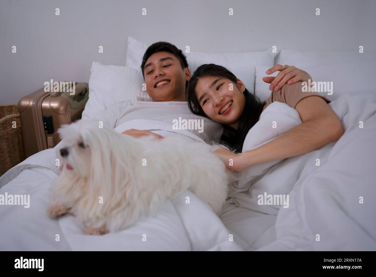 Jeune couple ensemble dans la chambre avec chien. Concept de style de vie et d'activités de loisirs. Banque D'Images
