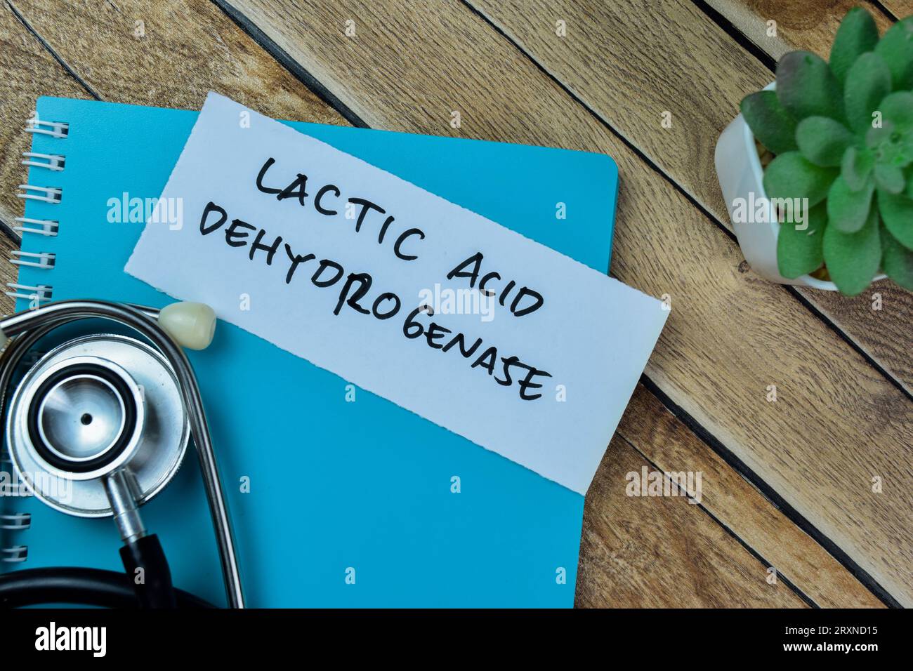 Concept d'acide lactique déshydrogénase écrire sur des notes adhésives avec stéthoscope isolé sur la table en bois. Banque D'Images