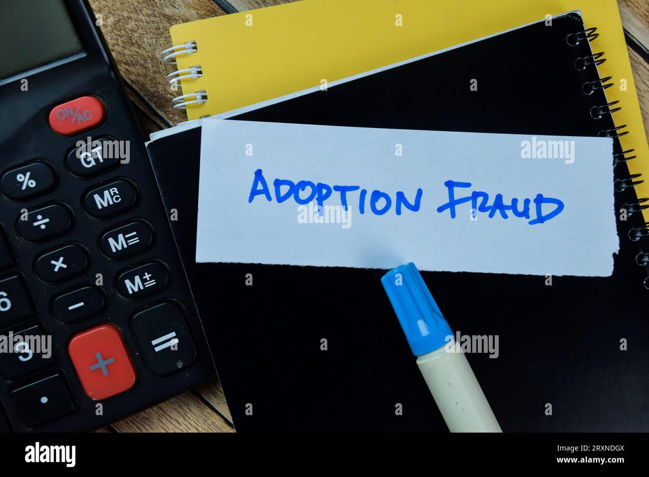 Concept de fraude d'adoption écrire sur des notes autocollantes isolées sur la table en bois. Banque D'Images