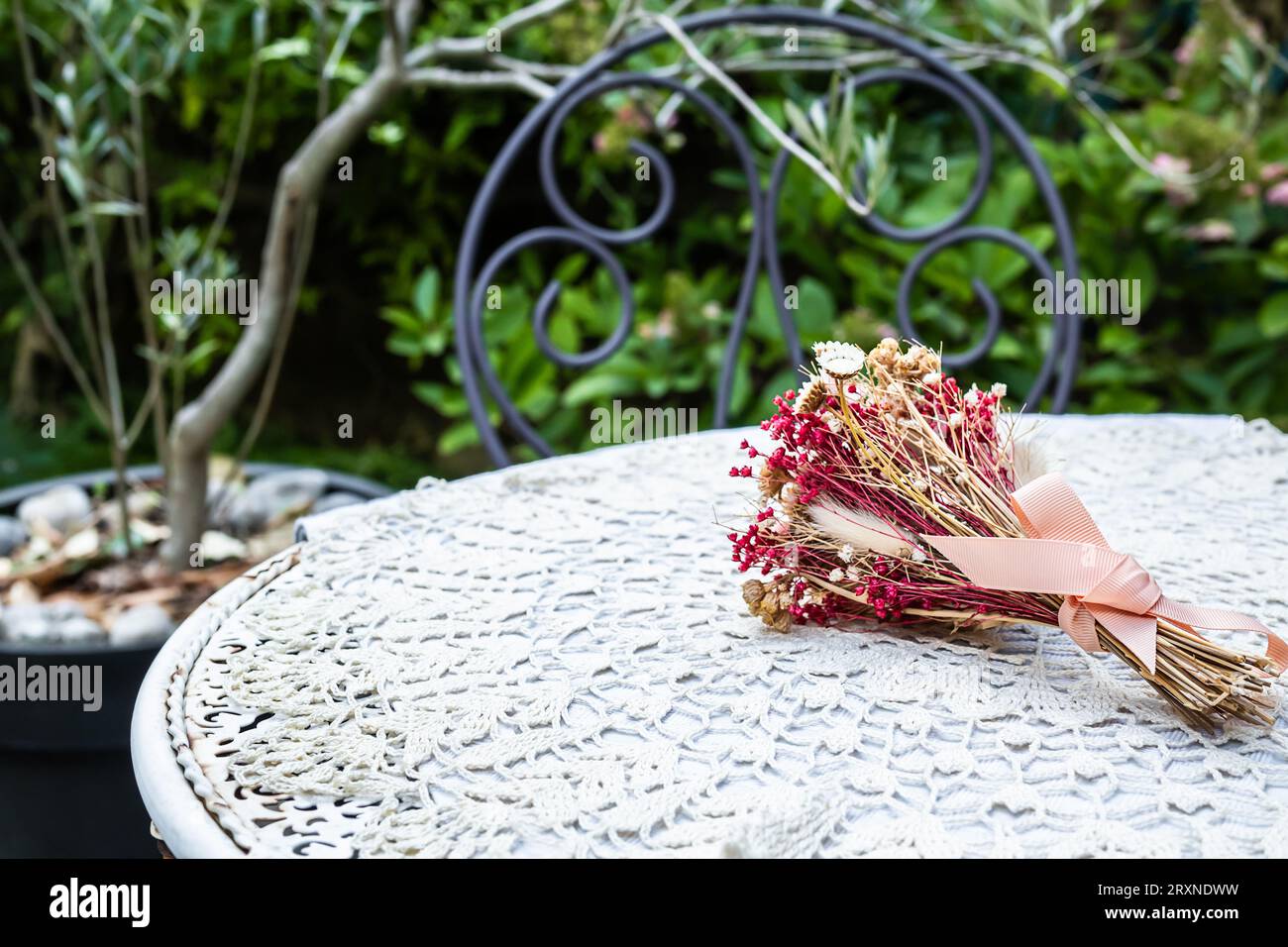 Bouquet d'herbes sur une table de jardin avec une serviette blanche dans le jardin, style de vie calme et concept cottagecore Banque D'Images