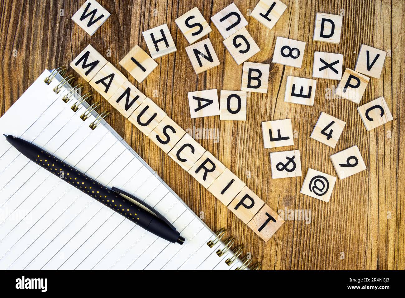 Manuscrit plat fait de lettres gravées au laser sur cahier de ligne vierge et stylo avec lettres éparpillées Banque D'Images