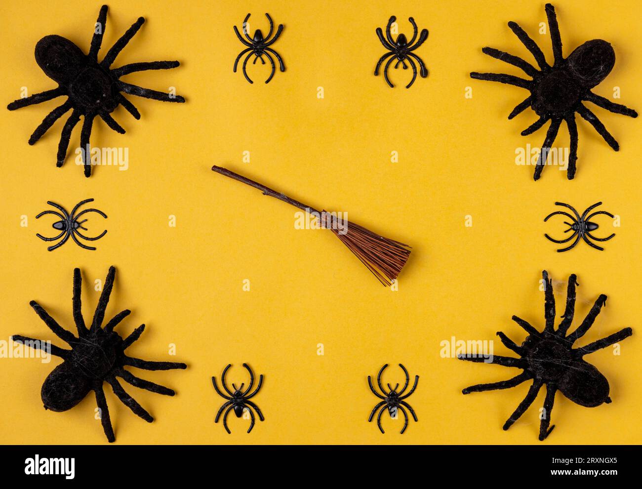 Araignées noires avec balai de sorcière sur jaune, cadre Banque D'Images