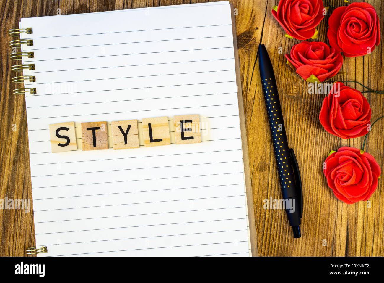 Style plat fait de lettres gravées au laser sur cahier de ligne vierge avec des roses Banque D'Images