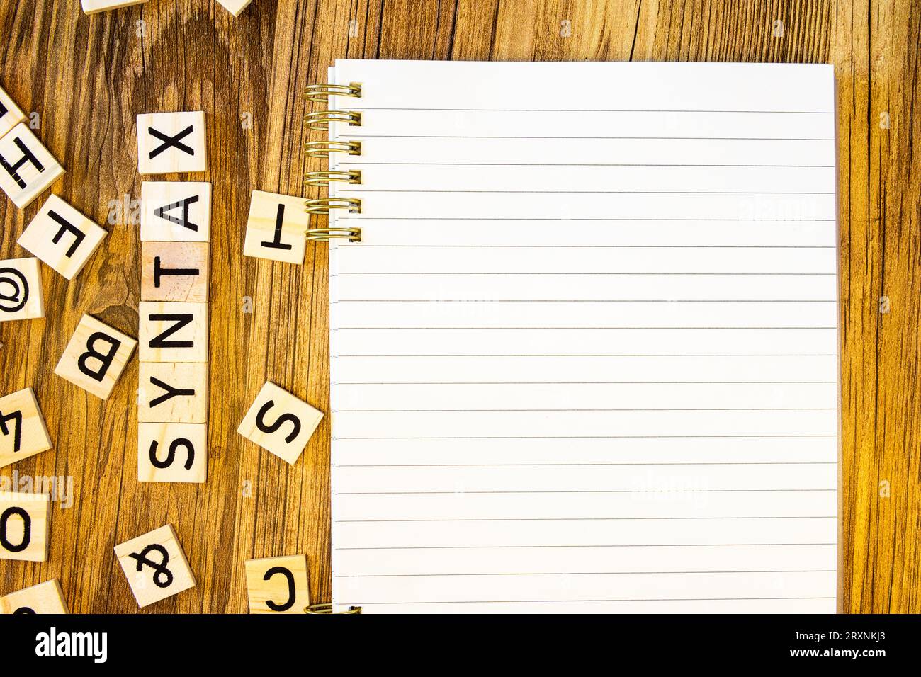 Syntaxe Flat lay fait de lettres gravées au laser sur cahier de ligne vierge avec des lettres éparpillées Banque D'Images