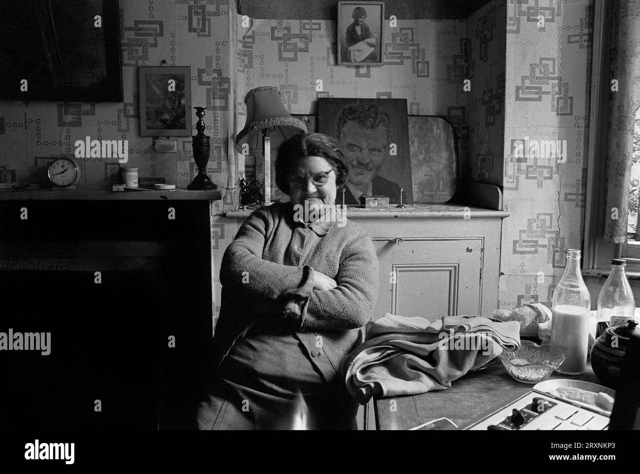 Dame âgée assise dans la salle de devant de sa maison victorienne qui attend la démolition pendant le nettoyage des bidonvilles de St ann's, Nottingham, Angleterre. Banque D'Images