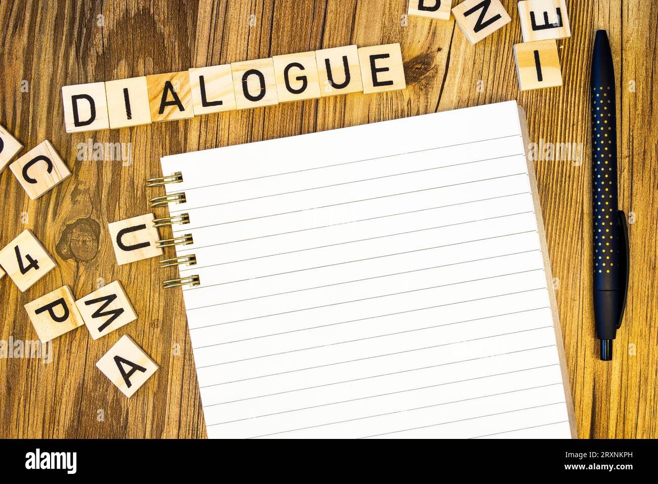 Dialogue plat fait de lettres gravées au laser sur cahier de ligne vierge avec des lettres éparpillées Banque D'Images