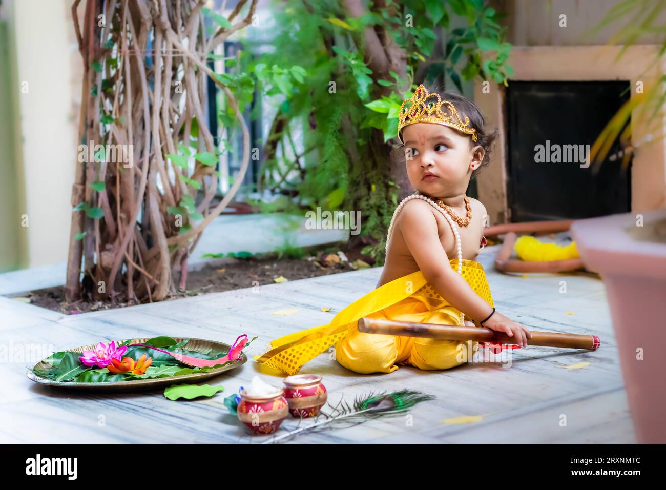 adorable bébé habillé comme dieu hindou krishna mignon expression faciale avec flûte à janmashtami Banque D'Images