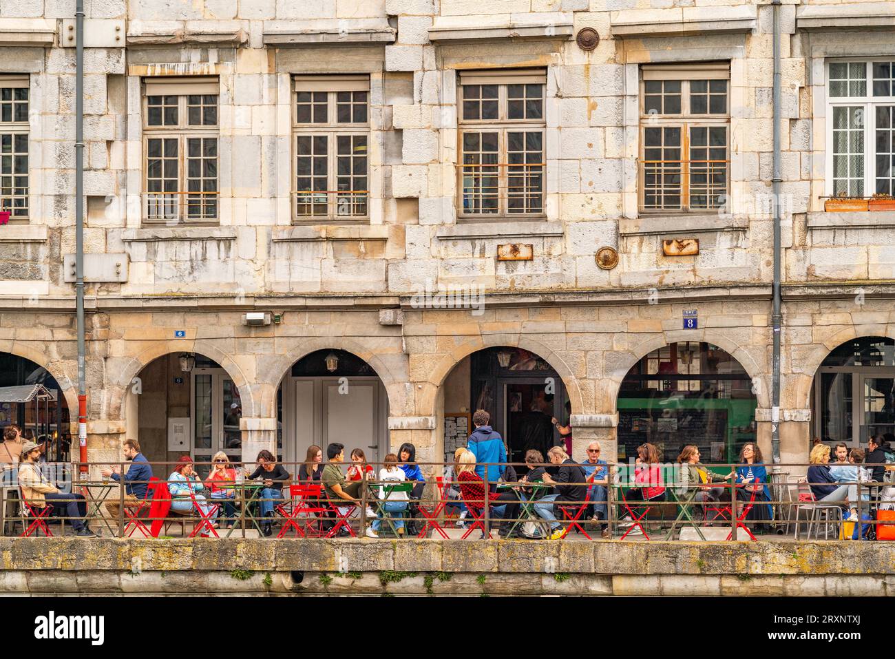 Les gens dans le café en face de l'architecture historique du Quai Vauban sur le Doubs, quartier battant, Besançon, Bourgogne-Franche-Comté Banque D'Images