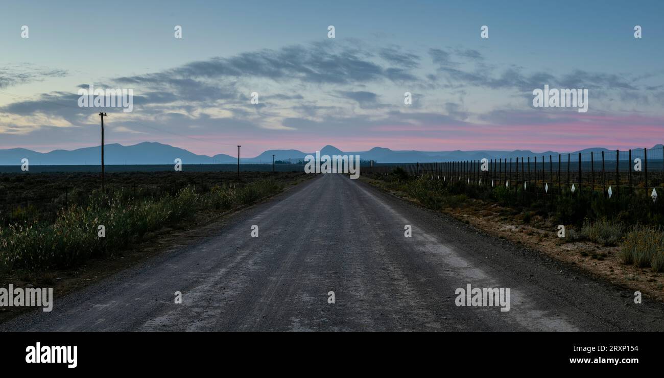 Perspective décroissante du chemin de terre vide au crépuscule, Touws River, Western Cape, Afrique du Sud Banque D'Images