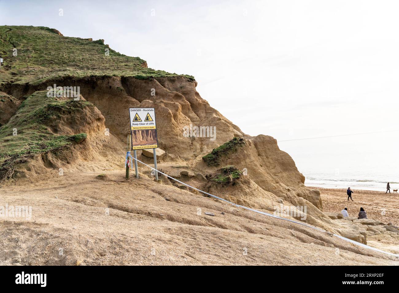 Panneau d'avertissement d'érosion côtière sur des falaises de grès instables à West Bay Beach Banque D'Images