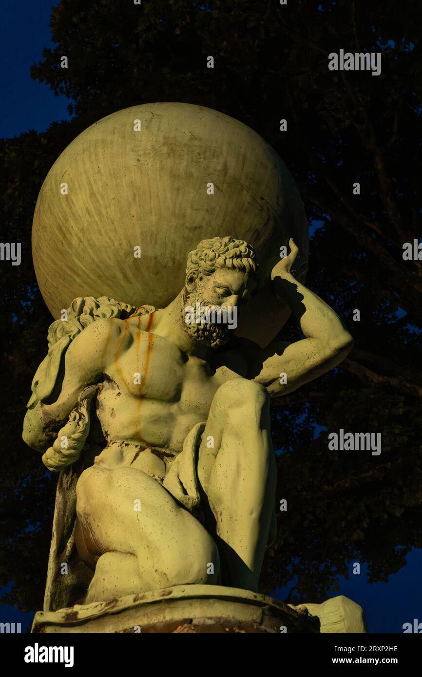 Statue classique de l'Atlas portant globe dans les jardins du village de Portmeirion au crépuscule Banque D'Images Statue classique de l'Atlas portant globe dans les jardins du village de Portmeirion au crépuscule Banque D'Images
