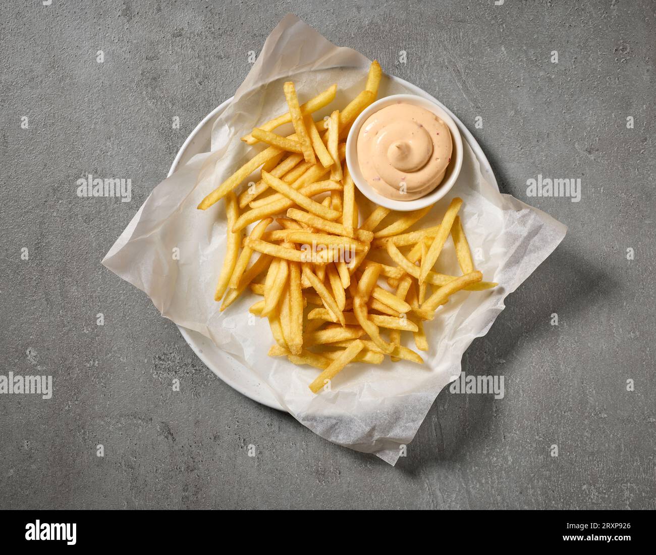 assiette de frites et sauce mayonnaise trempée sur la table grise, vue de dessus Banque D'Images
